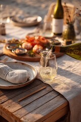 Fototapeta premium White wine pouring into glass on outdoor table set for dinner. Sea food platter with shrimp and appetizer on beach background. Summer evening picnic at sunset with beverage and snack.