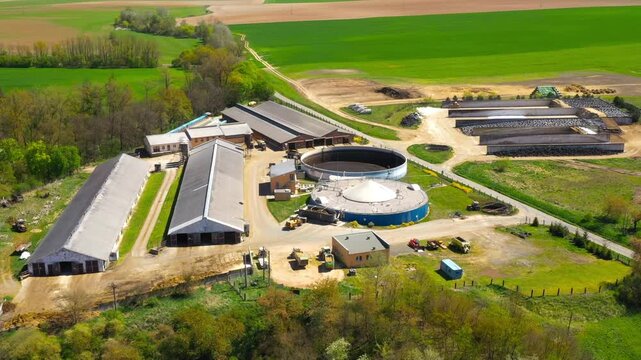Biogas plant and farm in fields. Renewable energy from biomass. Aerial view to Czech industry. Sustainable development in European Union.