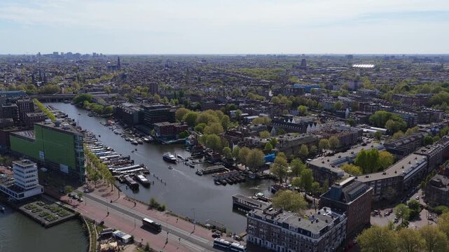 Amsterdam cityscape with urban canal, historic architecture, boat traffic from high above, showing vibrant city, traditional dutch houses, bustling marina