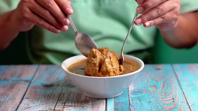 Indonesian is eating bakso gajah (bakso jumbo, giant meat ball). Bakso is one of indonesian street food.