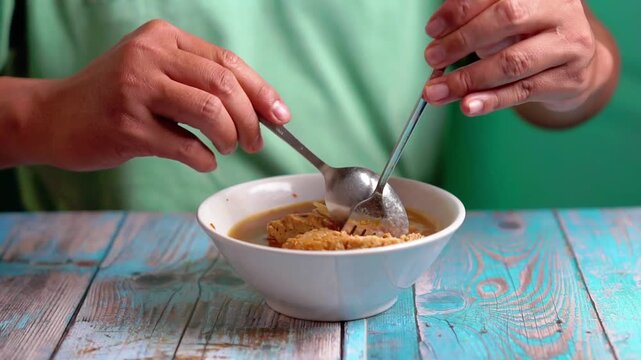 Indonesian is eating bakso gajah (bakso jumbo, giant meat ball). Bakso is one of indonesian street food.