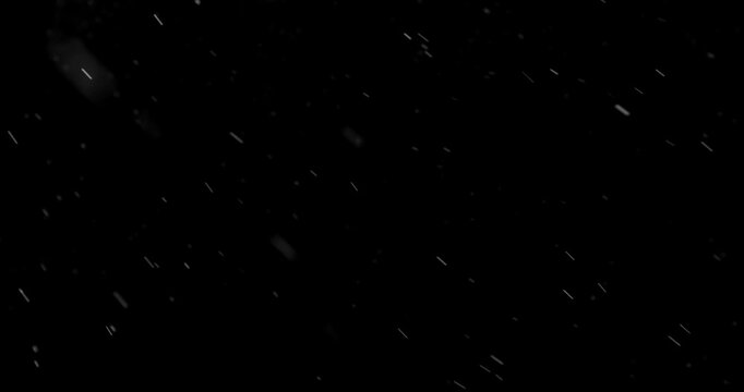 Slow Motion of Falling Realistic Snow, Dust or Rain Particles Captured on a Pure Black Background. Perfect as a VFX or Compositing Overlay for Winter Atmospheres, Transitions, and Visual Effects.
