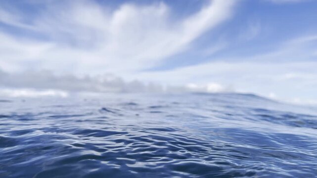 Vast open ocean sparkles with gentle rolling waves under expansive blue sky dotted with fluffy clouds creating soothing infinite seascape