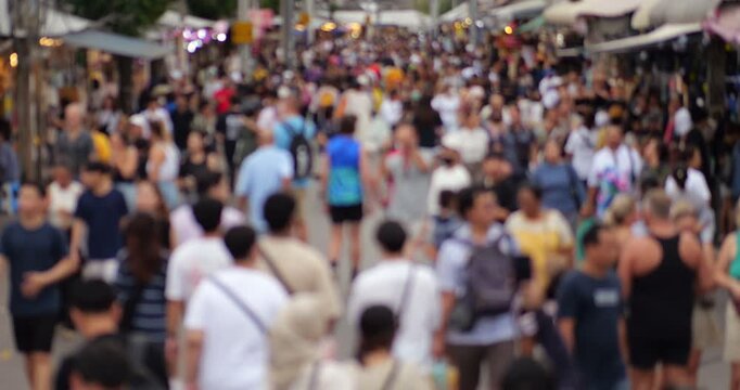 Non stop walking flow of people at Chatuchak weekend market, blurred view of wide pedestrian alley. Overhead perspective creates impression of continuous motion of pedestrians at the market