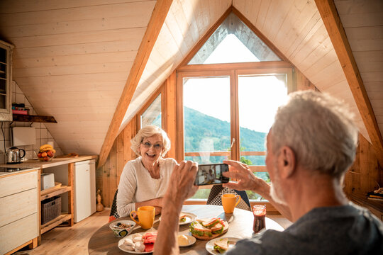 Senior couple enjoying breakfast in mountain cabin
