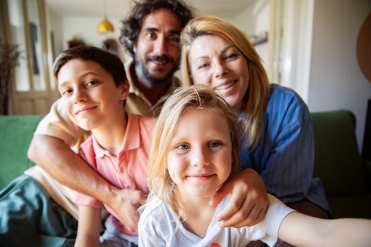 Happy family taking selfie on living room sofa
