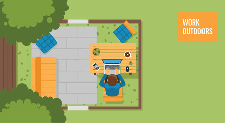 Fototapeta premium Aerial top view of a person working on a laptop at a wooden table in a peaceful outdoor garden patio workspace setting.