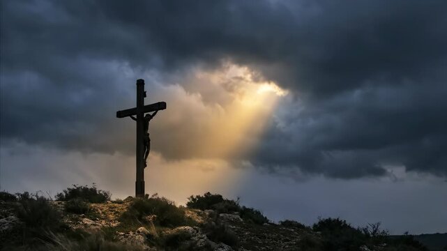 Jesus Christ on crucifix with dramatic sky and sunlight breaking through clouds for religious concept.