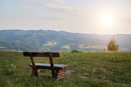 a wooden bench in the mountains invites to linger