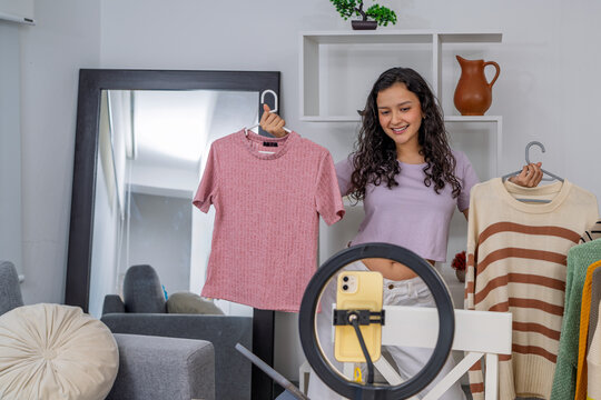 Young woman live streaming fashion review for social media