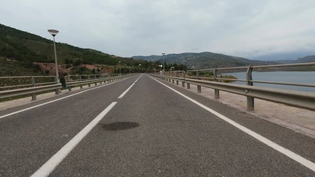 Driving on a concrete dam in Spaion. POV on-board camera. 4K Video footage, 50p, 10 bit