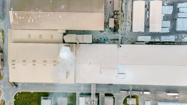 Aerial view of an industrial complex featuring large factory rooftops and a smoking chimney in Sabac, Vojvodina, Serbia.