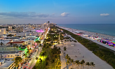 Fototapeta premium Drone shot of Miami on evening in Ocean Drive. Miami city with Ocean Drive at evening. Aerial view of Miami with Ocean Drive at night. Miami shoreline on Ocean Drive.