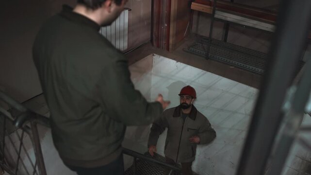 Dramatic Overhead Shot Of Authority Figure Confronting Technician During Tense Workplace Altercation. Media