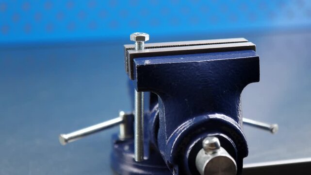 Metal vise fixed on a metal table.