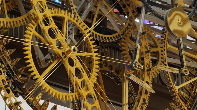 Golden clock mechanism showing intricate brass gears, clockwork, and mechanical engineering