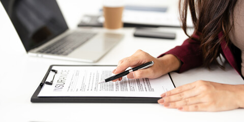 Fototapeta premium real estate agent professional reviewing documents while working on a laptop.