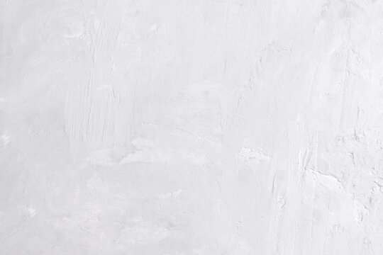 Minimalist aesthetic background of white cement or lime wall. Raw textured surface with subtle shadows
