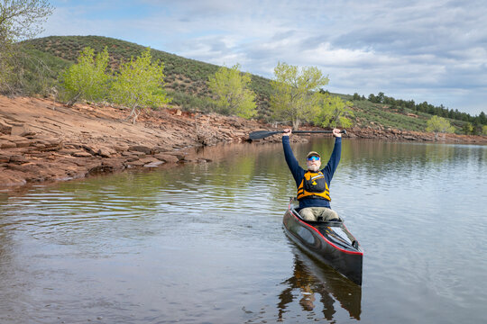 senior paddler is paddling a decked touring canoe on Horsetooth Reservoir - early spring scenery of Colorado foothills