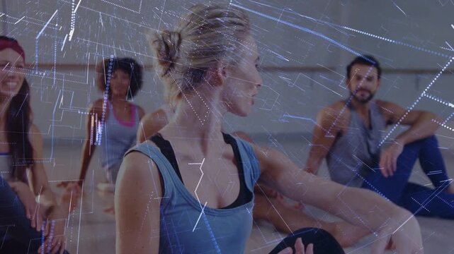 Instructor turning and guiding class in fitness studio, digital overlay appearing, aligning hand