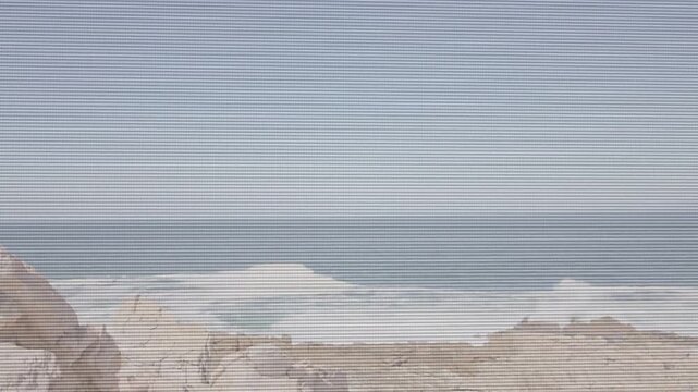 Swell cresting causing panning left waves breaking foam sliding trail fading scanline showing coast