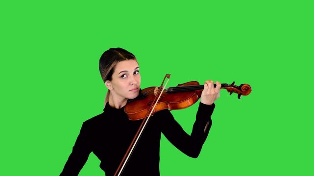 Elegant lady in black dress plays the violin, then stops and makes a bow on a Green Screen, Chroma Key.