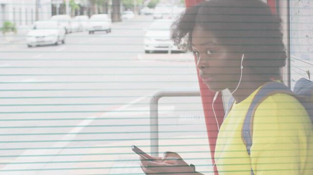 Woman waiting at bus shelter, scrolling phone, tapping screen, lifting head, smiling toward camera