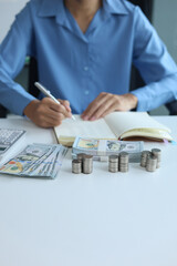 Fototapeta premium Three stacks of coins arrange separated on the table while businessman writing in a notebook. Concept for financial planning or budgeting.