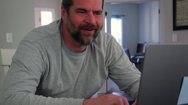 Older man using a laptop to answer social media quiz questions illustrating the dangers of oversharing personal data and cybersecurity risks