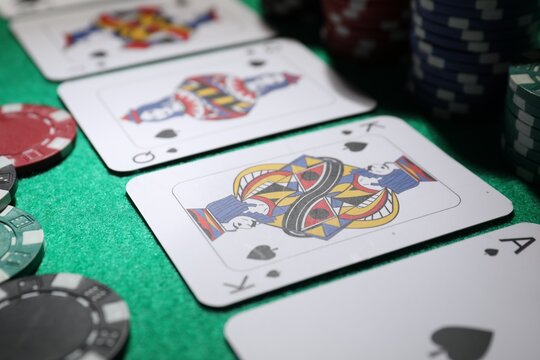 Casino chips and playing cards on green table, closeup
