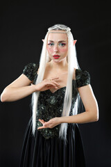 Naklejka premium Beautiful girl dressed as elf on black background