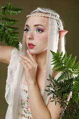 Naklejka premium Beautiful elf girl with floral decor on dark olive background
