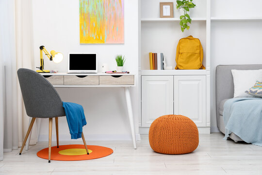 Stylish workplace with laptop and stationery in child's room