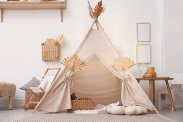 Stylish wigwam with dry leaves in child's room © New Africa