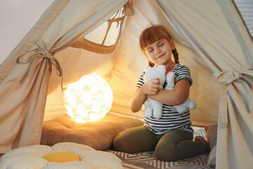 Little girl playing with toys in wigwam at home © New Africa