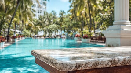 Obraz premium Marble table sits empty. Blurry pool water shimmers. Tropical hotel setting offers summer vibes.