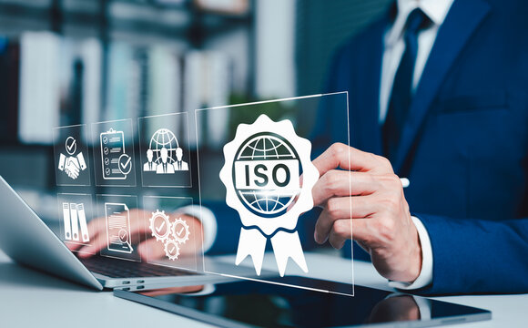 ISO certification standards and compliance management concept. Business professional reviewing ISO badge, audit icon, and quality documents representing certification control, verification, governance
