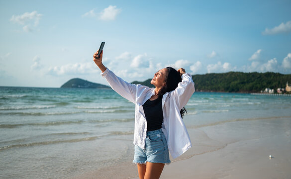 Influencer taking a selfie on a tropical beach, enjoying vacation, social media content creation