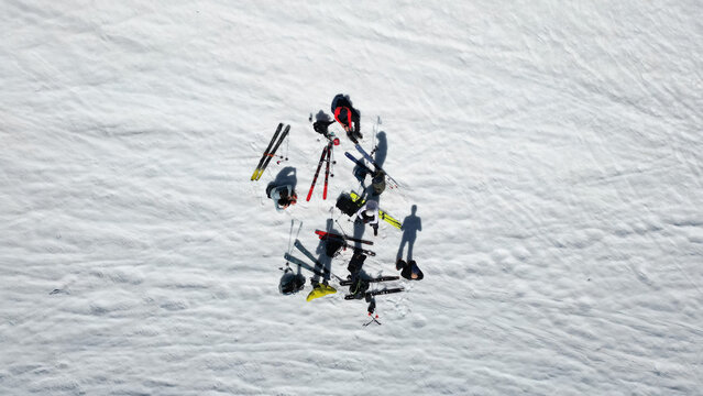 Aerial view of a group of skiers resting with their equipment on the snowy slopes of Pointe Ronde near Trient, Valais, Switzerland.