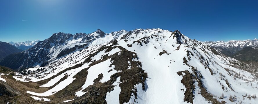 Aerial view of Pointe Ronde mountain peak covered in snow with rugged ridges and alpine slopes under a clear blue sky in the Swiss Alps near Trient, Valais, Switzerland.