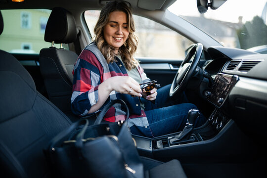 Young woman preparing to drive finding sunglasses in car