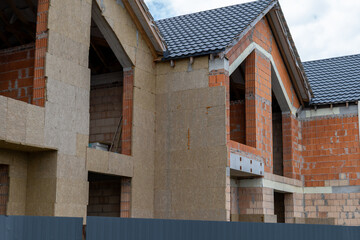 Obraz premium Workers are building new houses at a construction site. The walls are partially finished with visible bricks and materials