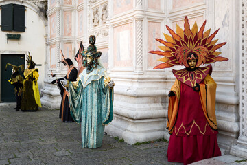 Naklejka premium Venice, Italy - February 17, 2026 - People dressed in masks for the Venice Carnival have their photos taken by tourists