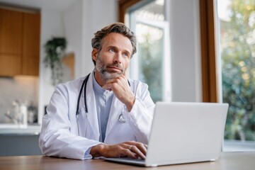 Obraz premium Plastic surgeon sitting at a desk reviewing patient charts on a laptop, modern clinic background,