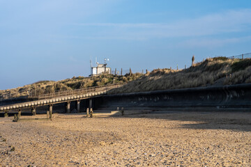 Fototapeta premium The coast guard hut and wooden ramp on Cart Gap beach, Norfolk coast
