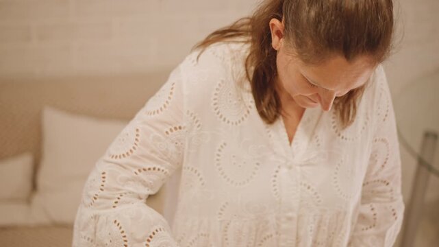 Woman leaning over mixing bowl, shaping crust in bright kitchen, focused home baker smoothing pie edge, warm autumn light, delicate lace blouse, calm attentive motion, closeup of handcrafted pumpkin