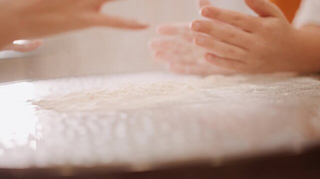 White hands clapping flour into air above prepared pumpkin pie base, playful family moment with airborne dust cloud, laughter and joy in sunlit kitchen, finishing touch captures soft texture