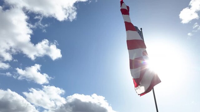 Cinematic Orbit Shot of American Flag Waving Against Cloudy Sky