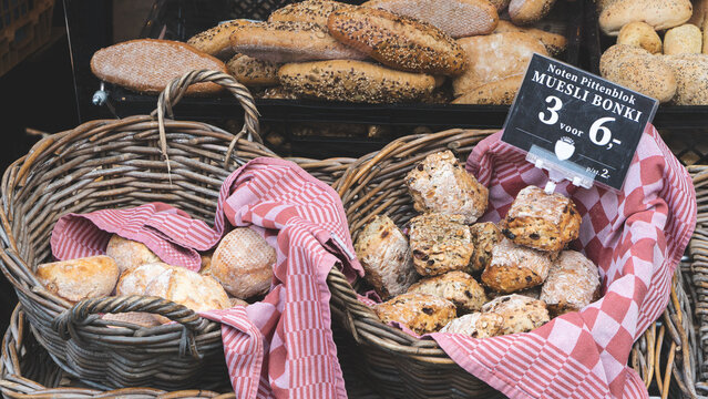 Fresh rustic bread loaves stacked on red cloth