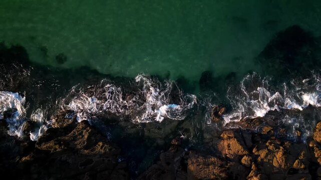 Top down view of Brittany rocky coast with waves crashing against them
